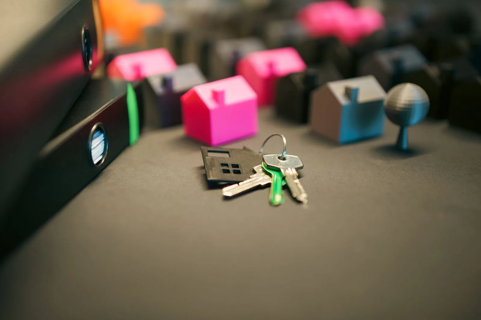 House keys beside small model homes on a desk, marking closing day on a Maine mortgage