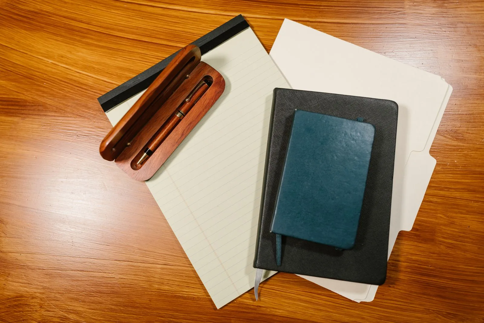 Reviewing FHA closing costs on a Loan Estimate Notebook, pens, and loan documents on a wooden desk, ready to review FHA closing costs