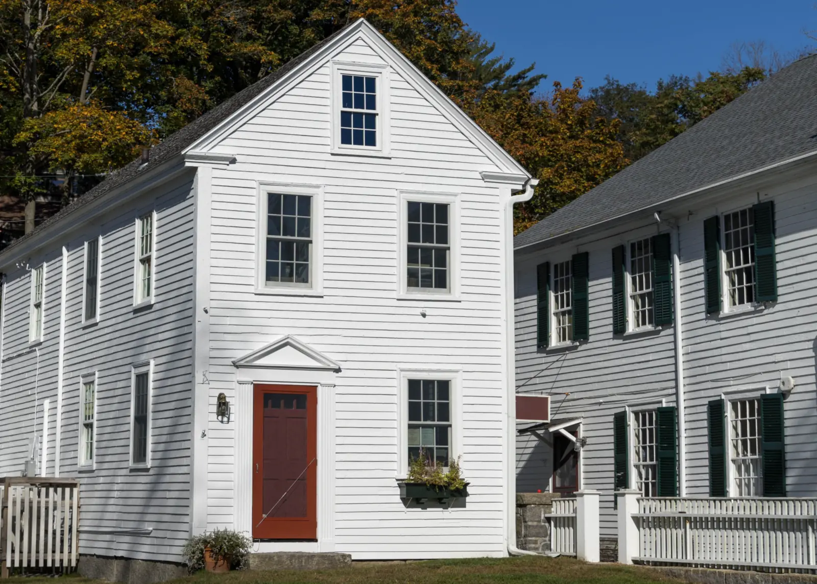 White clapboard older New England home with a red front door, the kind of Portland area house an FHA appraiser reviews