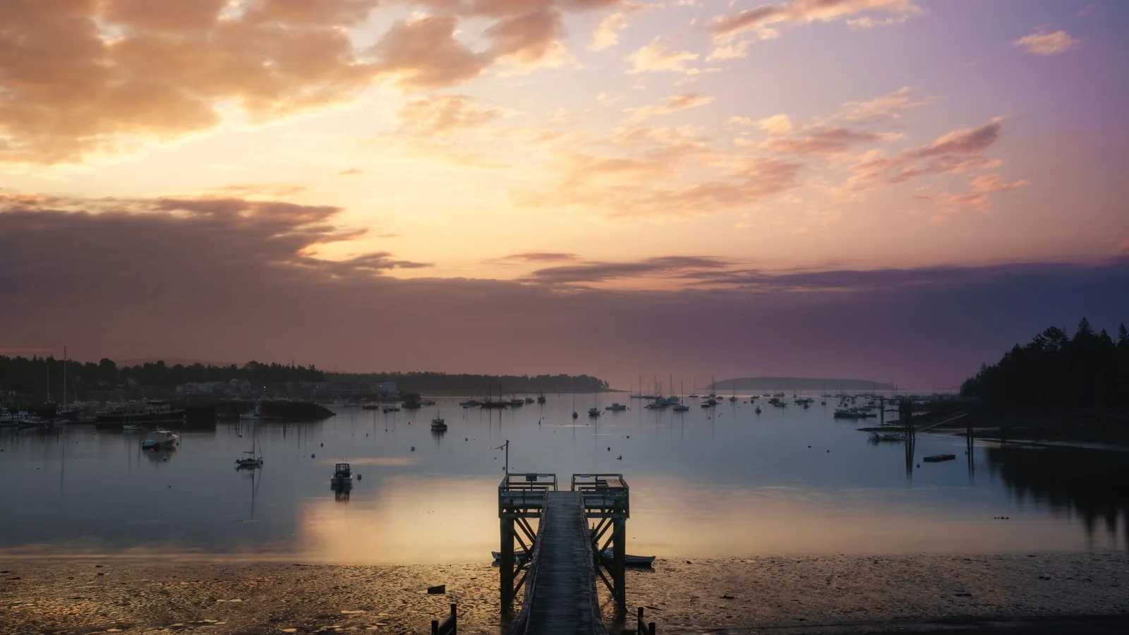 FHA loans near me in Maine and Florida Sunset over a calm Maine harbor with moored boats and a wooden pier, for a guide to FHA loans near me