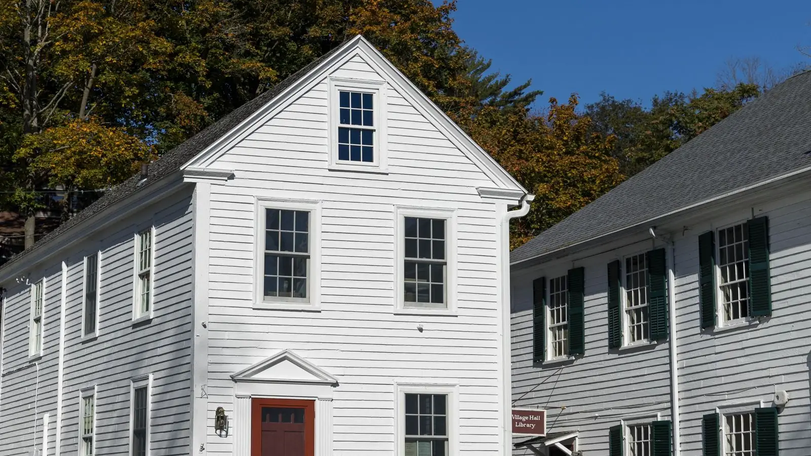 White New England colonial home with black shutters and a red door, for a guide to getting a mortgage in Portland, Maine