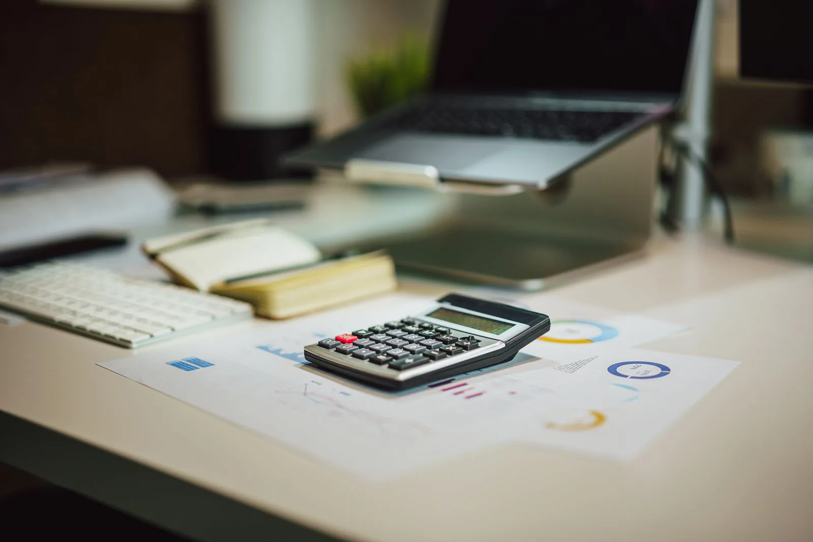 Comparing rent with the full payment on a DSCR loan Calculator and printed charts on a desk, used to compare rent with the full payment on a DSCR loan