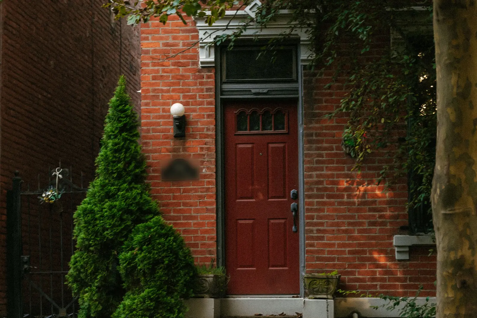 Red front door on an older brick row house in Cincinnati, the kind of city home investors buy to rent