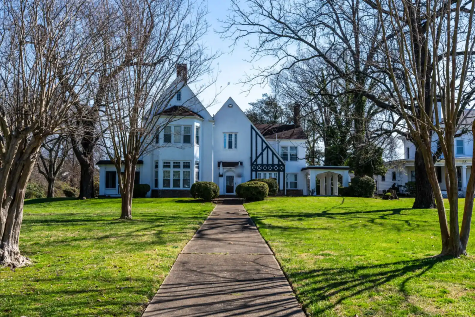 White Tudor Revival house with dark half timbering at the end of a long front walk in Hampton, Virginia