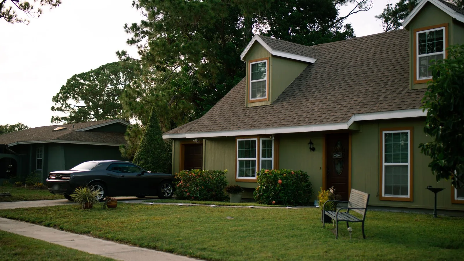 Green Cape style house with dormers and a front lawn