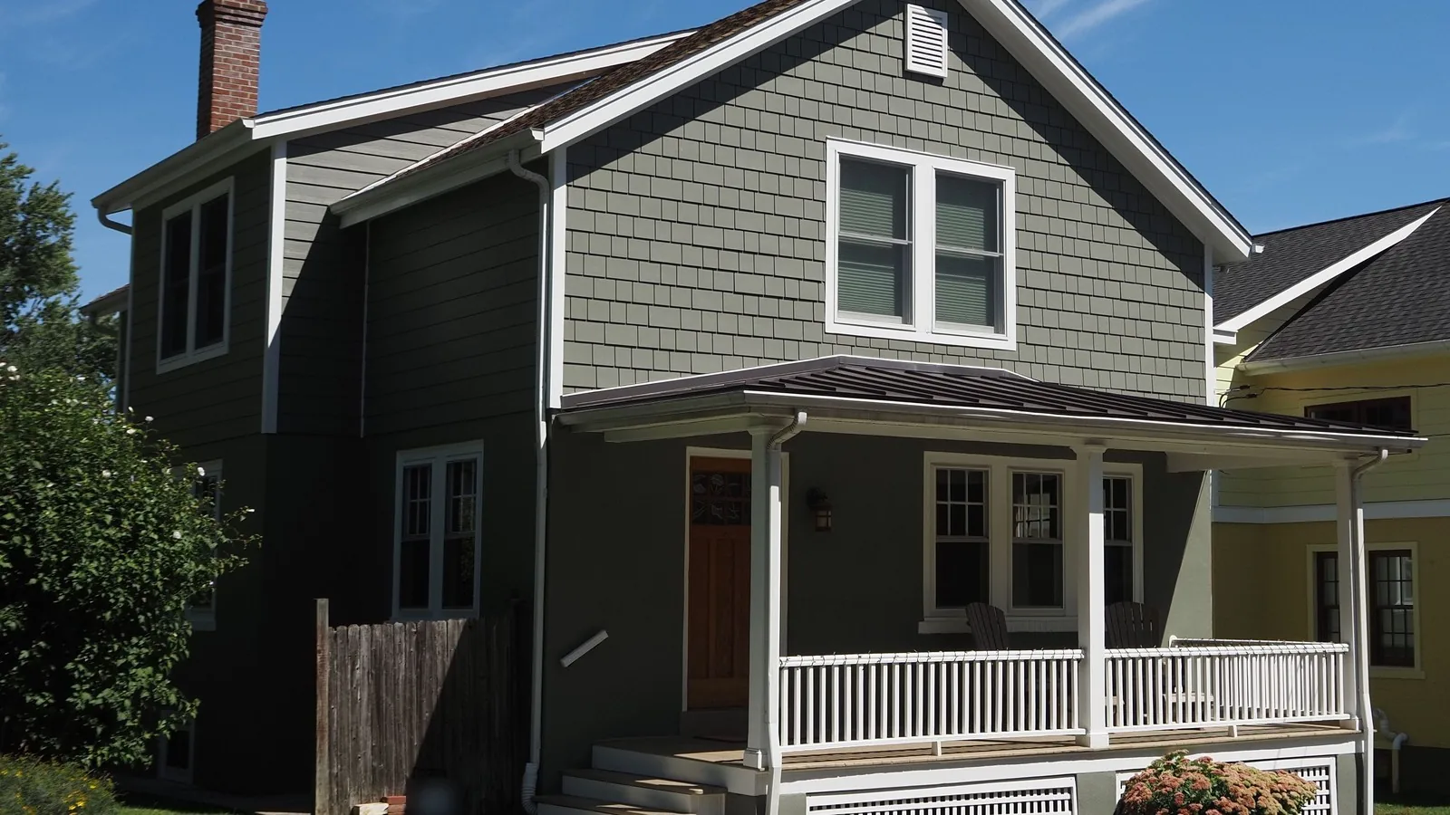 A two story sage green shingle house with a white railed front porch, for a guide to hybrid appraisals and the new UAD 3.6 appraisal form