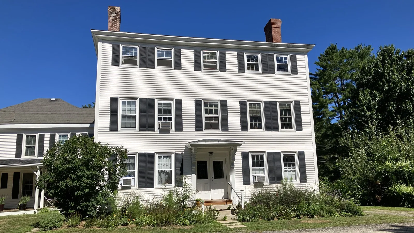 White Federal style home with dark shutters in Yarmouth, Maine
