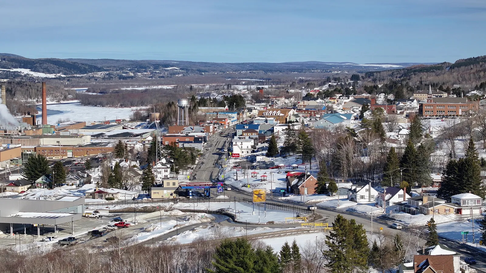 Winter view over homes and Main Street in Madawaska, Maine, with the frozen Saint John River beyond