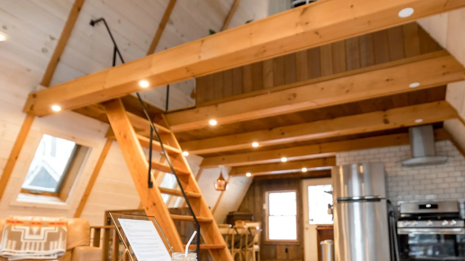 Sunny loft cabin interior with a wood beamed ceiling