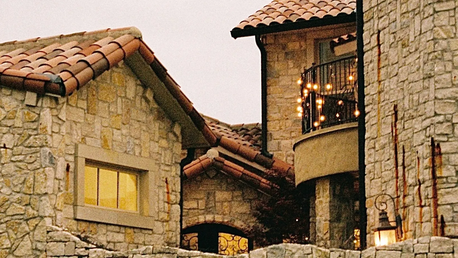 Stone house with a turret behind a stone wall