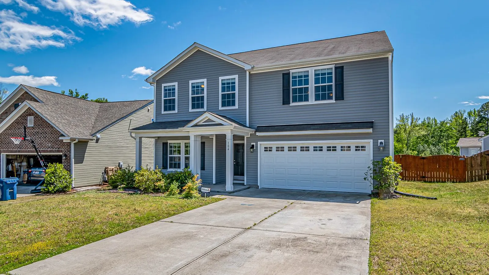 Gray two story house with a driveway and garage