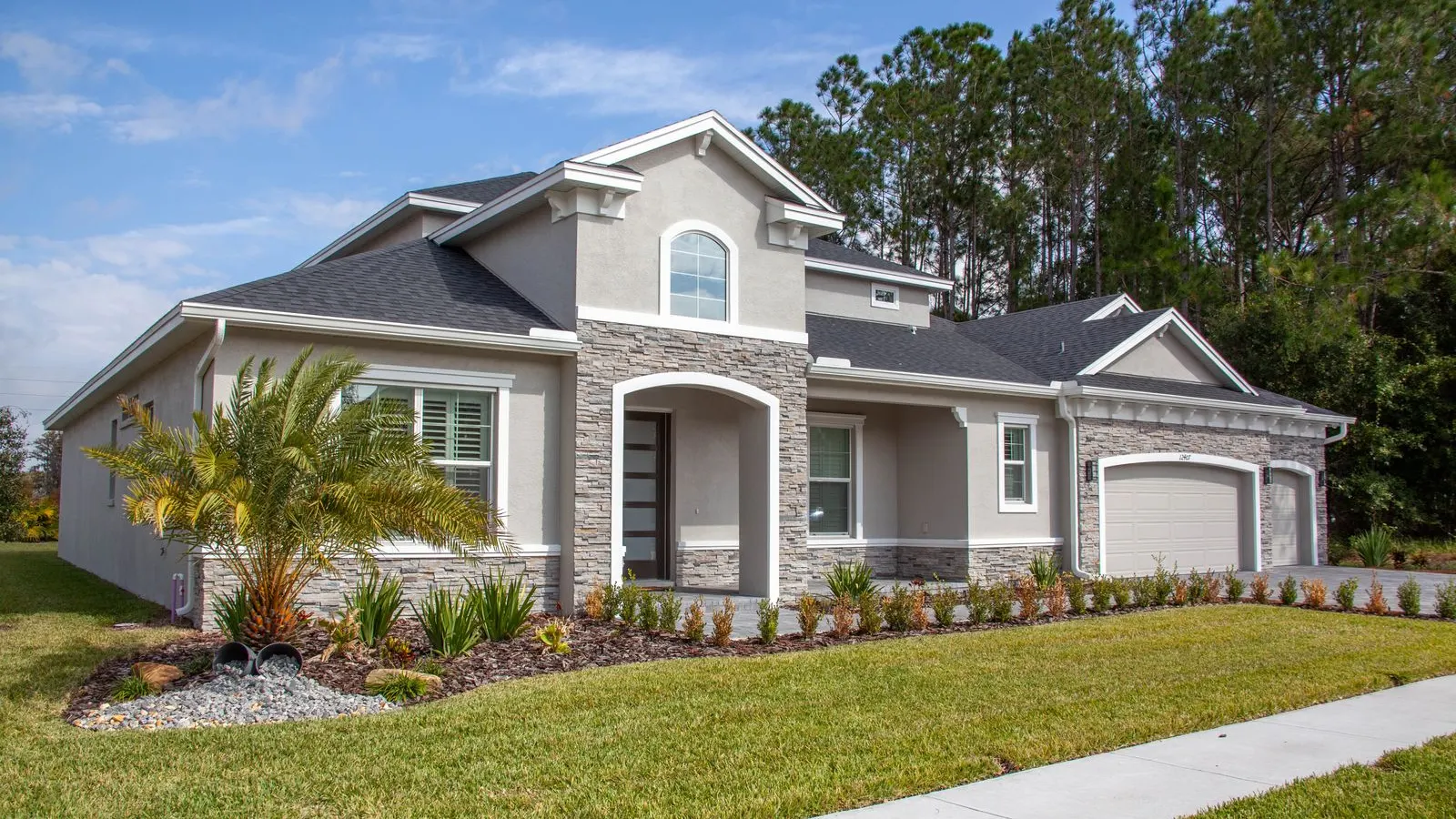 Gray Florida home with palms and a wide lawn