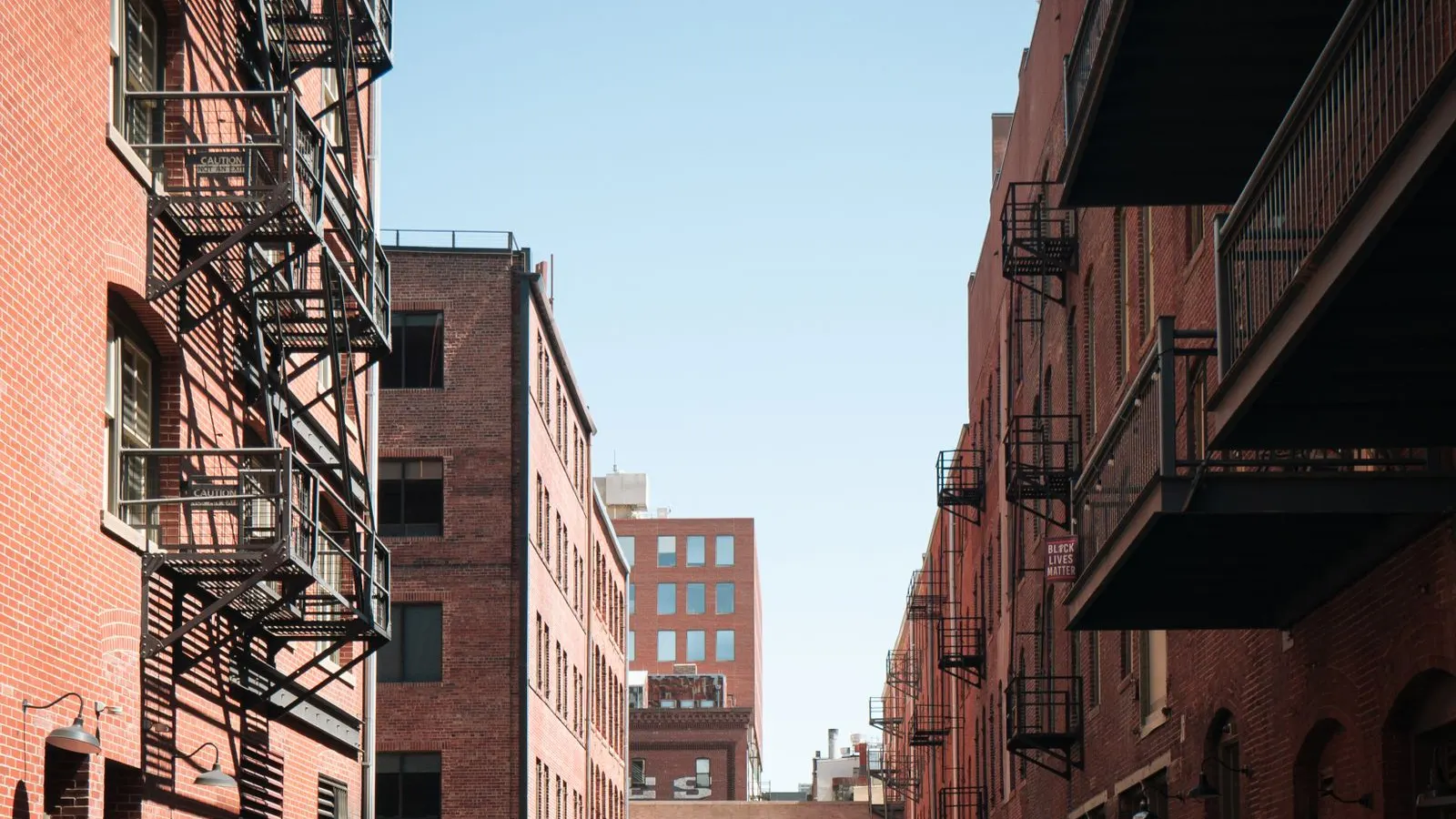 Brick townhouses with balconies along a Denver alley