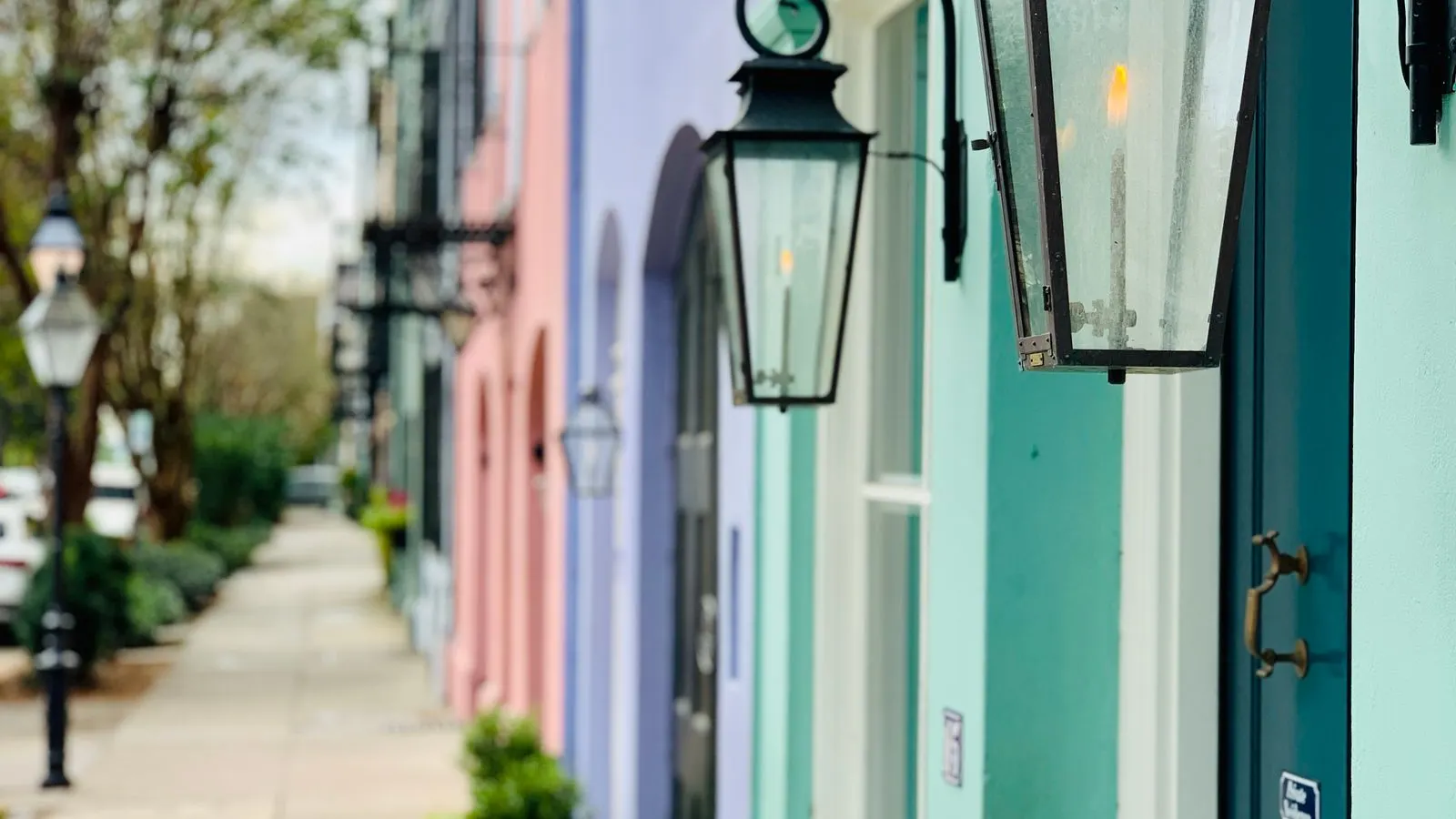 Colorful historic houses along a Charleston sidewalk