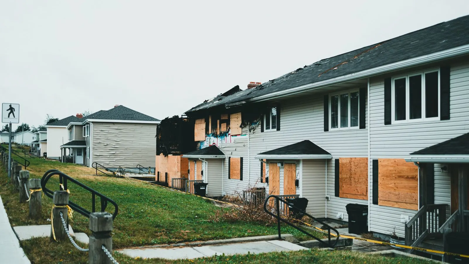 Row of houses with boarded windows waiting for repair