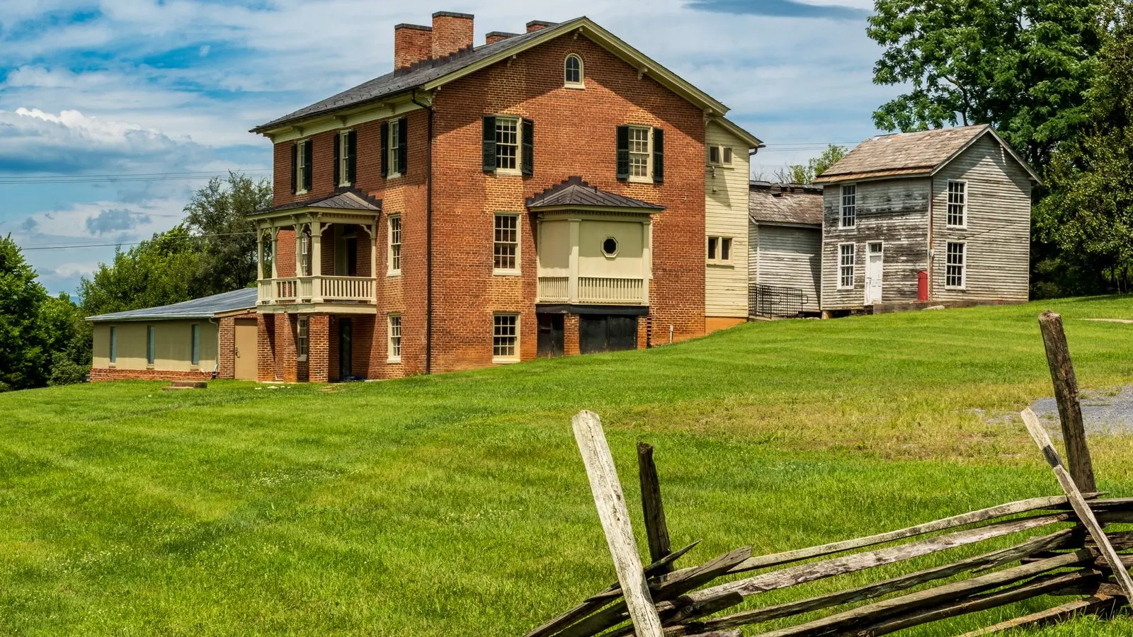 Brick colonial house above a green lawn