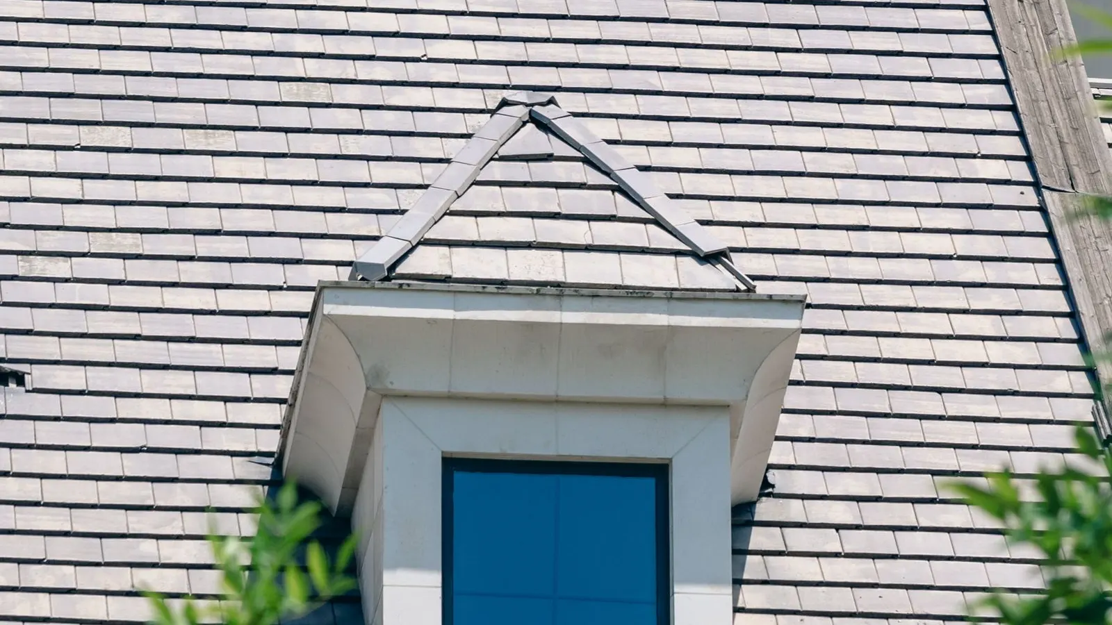Dormer window on the shingled roof of a Cape style house