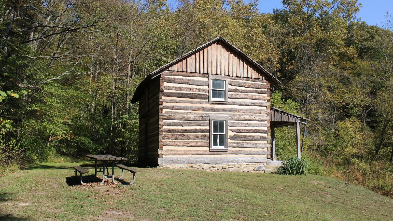 Log cabin in a clearing at the edge of the woods