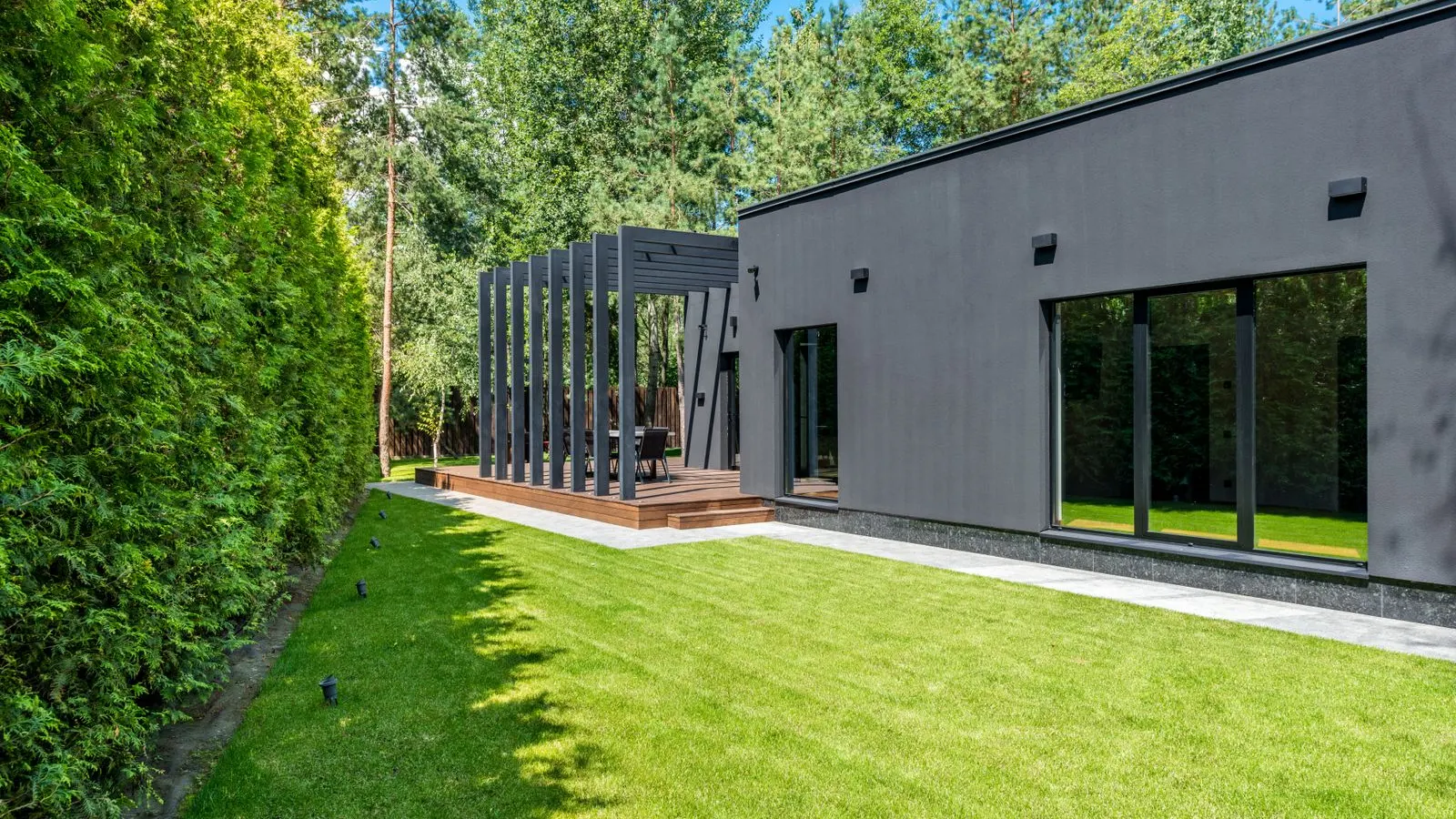 Modern dark sided house with a long green lawn