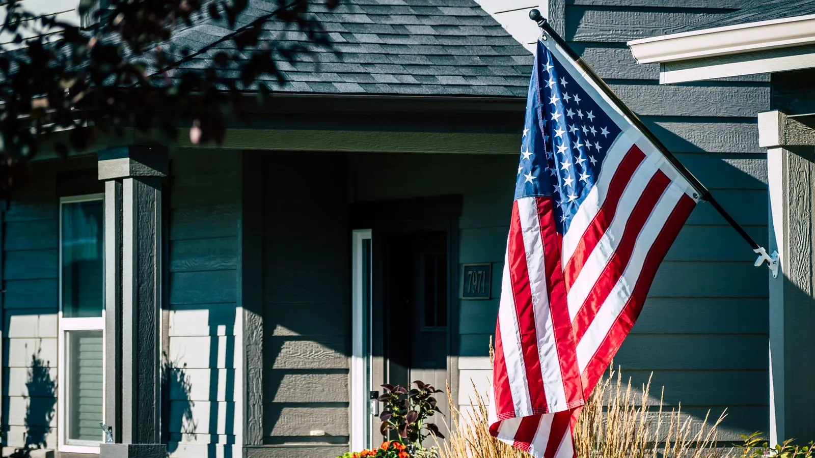 American flag outside a blue gray house
