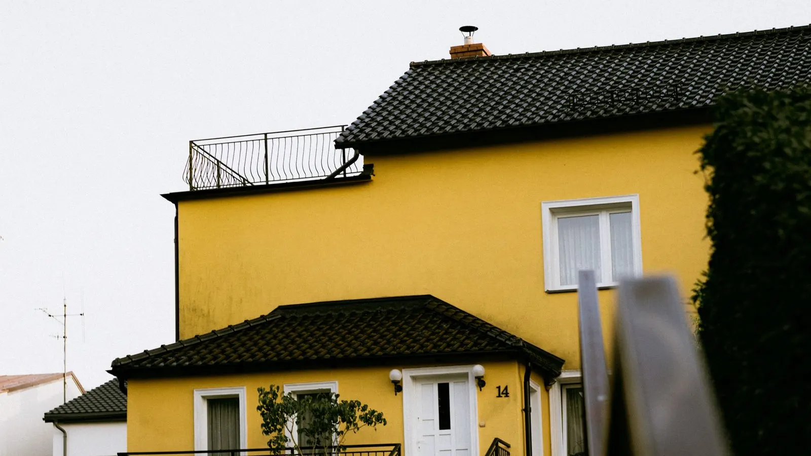 Yellow house with a balcony above a stone stairway