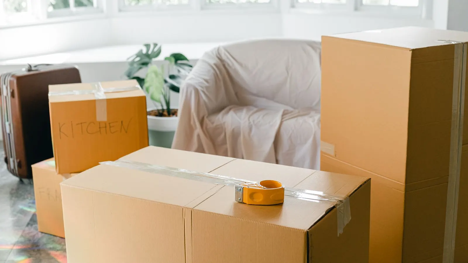 Packed moving boxes in a sunny empty apartment
